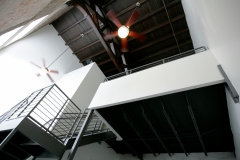 Second floor metal staircase leading to loft bedroom area at The Lofts San Marco